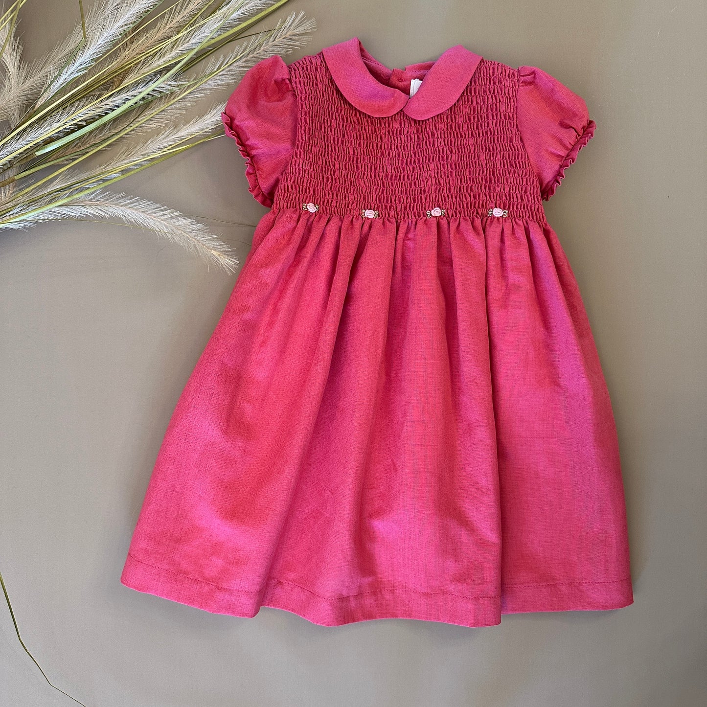 Abito in punto smock color fragola: eleganza e lavorazione raffinata