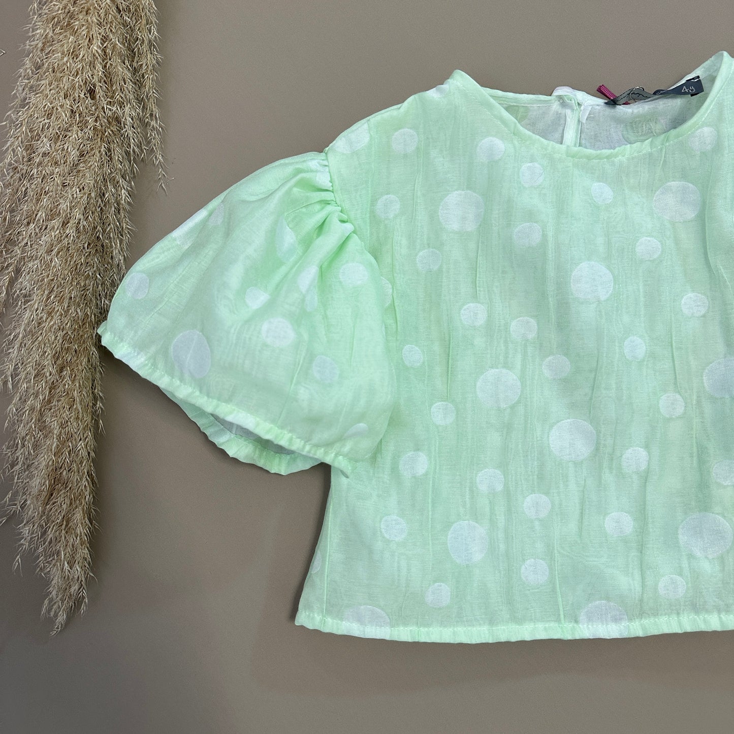 Top con manica a campana color salvia a pois - eleganza e stile senza tempo