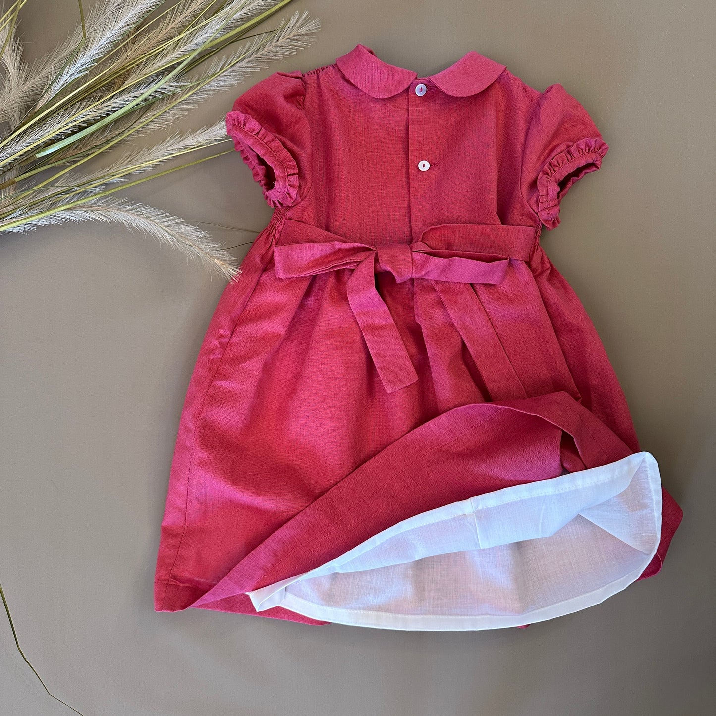 Abito in punto smock color fragola: eleganza e lavorazione raffinata