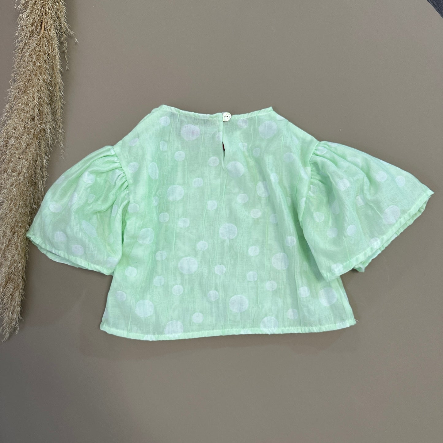 Top con manica a campana color salvia a pois - eleganza e stile senza tempo